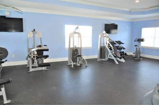 A gym with a variety of equipment including treadmills, stationary bikes, and weight machines.