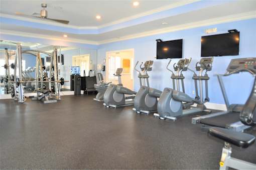 A gym with treadmills, weights, and exercise equipment.