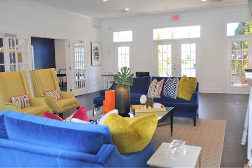 A living room with a blue couch and yellow chairs.