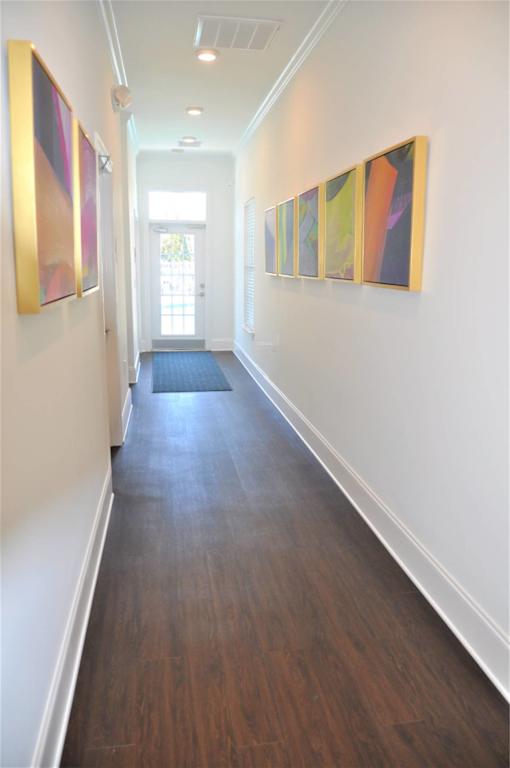 A hallway with a series of paintings on the wall.