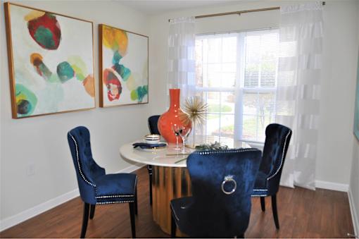 A dining room with a white table and blue chairs.
