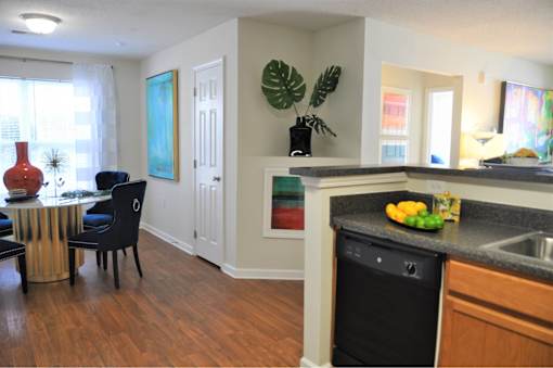 A kitchen with a black dishwasher and a black chair.