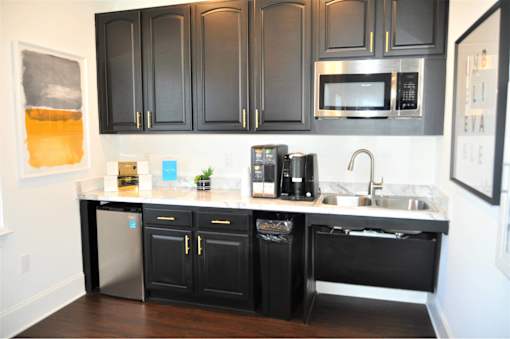 A kitchen with black cabinets and a stainless steel dishwasher.
