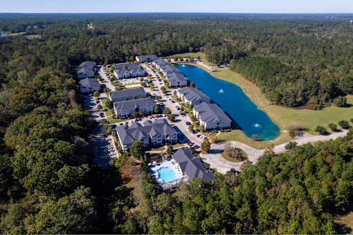 A bird's eye view of a resort with a swimming pool and a lake.