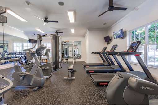 A gym with treadmills, elliptical machines, and other exercise equipment.