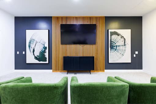 Two green chairs are in front of a television.