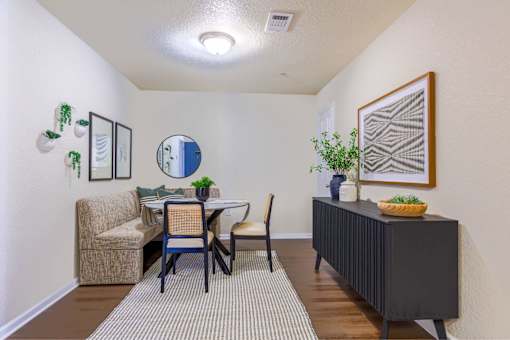 A dining room with a table and chairs.