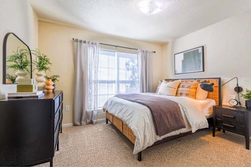 A bedroom with a large bed and a dresser.