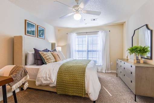 A bedroom with a bed, dresser, and mirror.