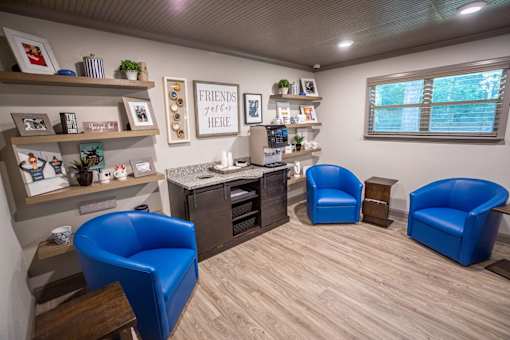 A room with blue chairs and a sign that says "Friends welcome here.".