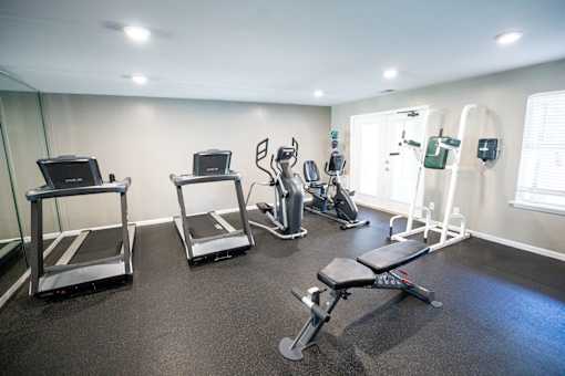 A gym with treadmills, exercise bikes, and other equipment.