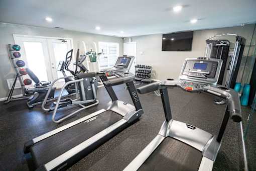 A gym with treadmills, exercise bikes, and other equipment.