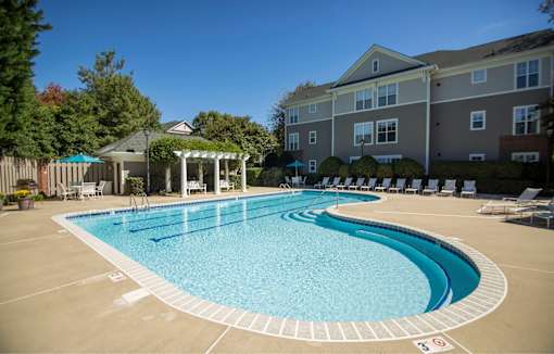 A large outdoor swimming pool with a pavilion and sun loungers.