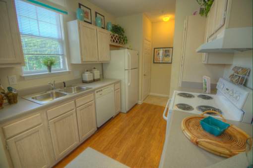 A kitchen with wooden cabinets and a white stove top oven.