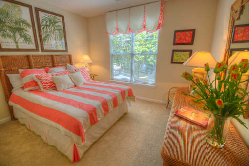 A bedroom with a large bed and a window with curtains.