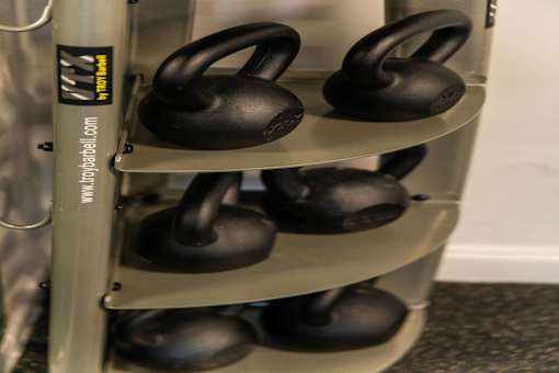 A set of kettlebells are stacked on a rack.