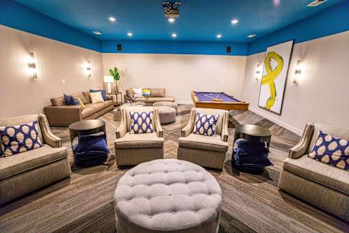 A room with a pool table and comfortable seating.