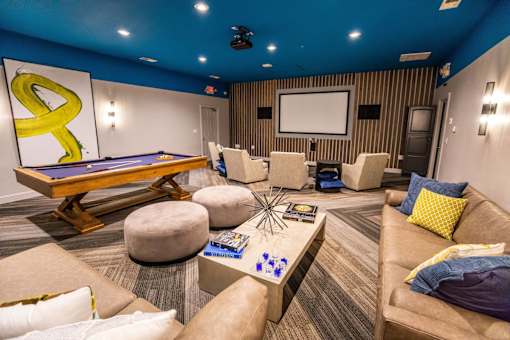 A room with a pool table and a couch.