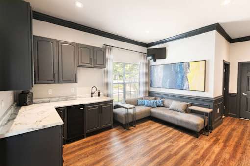 A kitchen with black cabinets and a marble countertop.