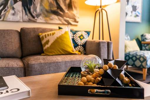 A table with a tray of decorative items and a book is in the foreground.