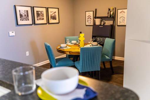 A dining table with four chairs and a bowl on the table.