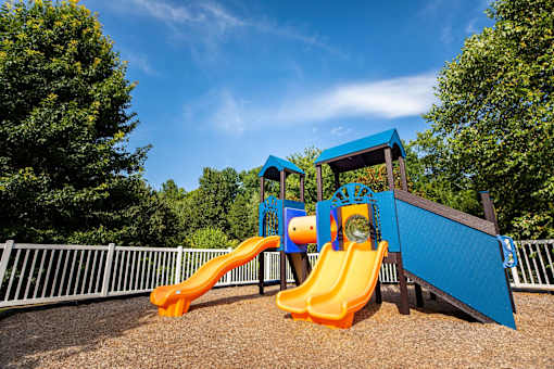 A playground with a blue and orange slide.