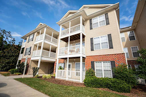 A two-story apartment building with a balcony on the second floor.