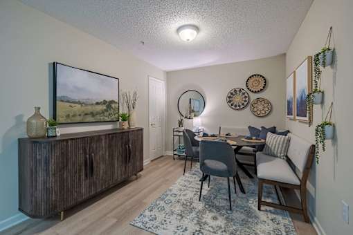 A dining room with a wooden table and chairs.