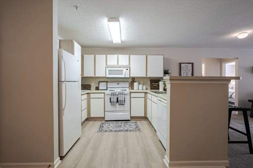 A kitchen with white appliances and cabinets.
