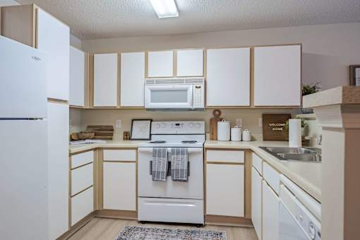 A kitchen with white appliances and cabinets.