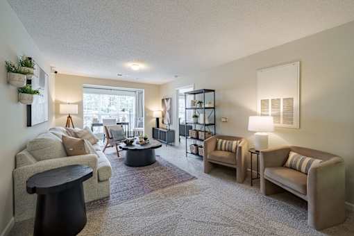 A living room with a grey carpet and furniture.