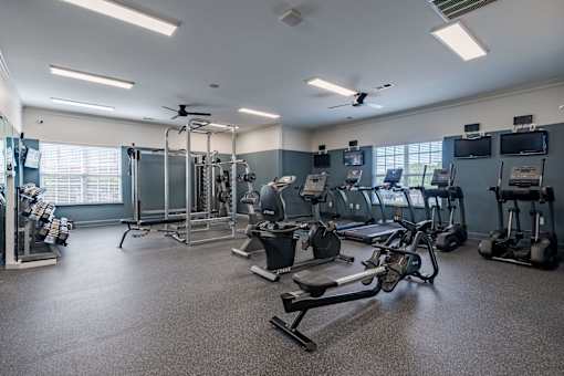 A spacious gym with a variety of equipment including treadmills, weights, and exercise machines.