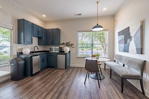 A kitchen with dark wood cabinets and a grey bench.