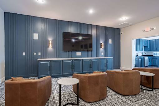 A room with a television, chairs, and a table.