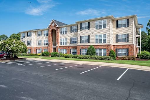 A large brick building with a parking lot in front.