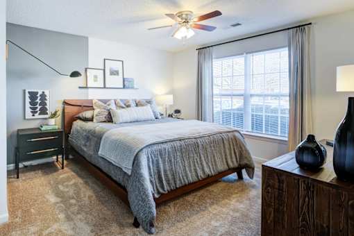 A bedroom with a large bed and a ceiling fan.