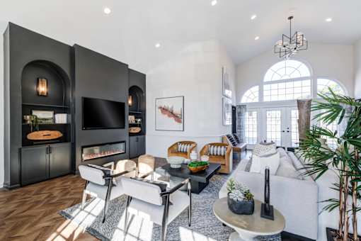 A modern living room with a fireplace and a large window.