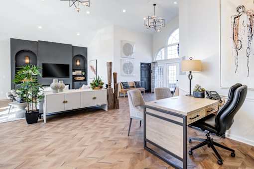 A modern home office with a wooden desk and black office chair.