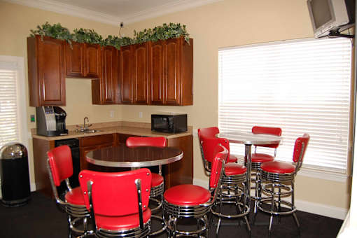 A kitchen with red chairs and a table.