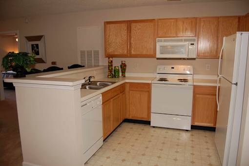 A kitchen with wooden cabinets and white appliances.