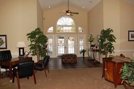 A living room with a ceiling fan and a large window.