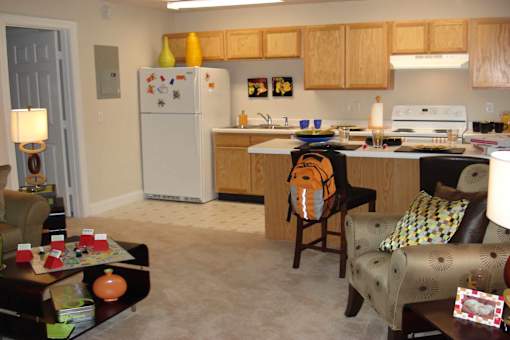 A kitchen with a refrigerator, sink, and stove.