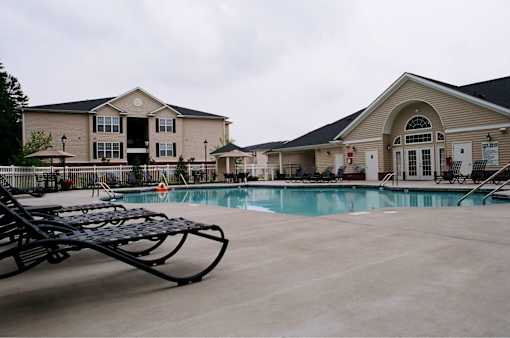 A pool area with a slide and a building in the background.