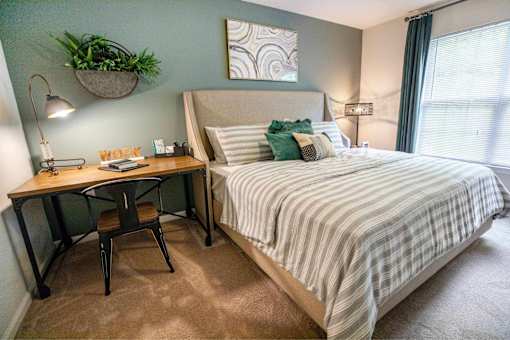 A bedroom with a bed, desk, and chair.