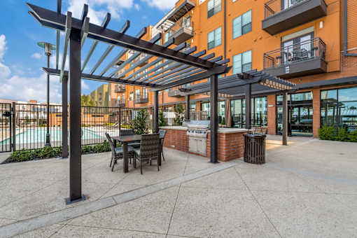 A patio with a table and chairs under a pergola.