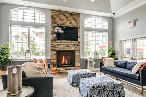 A living room with a fireplace and a TV mounted above it.