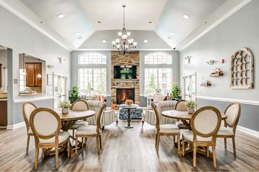 A dining room with a fireplace and a chandelier.