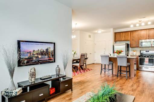 A modern kitchen with wooden floors and a large painting on the wall.