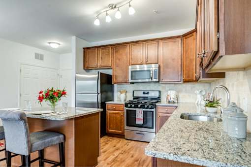A kitchen with granite countertops and stainless steel appliances.