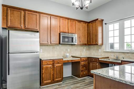 A kitchen with wooden cabinets and a granite countertop.